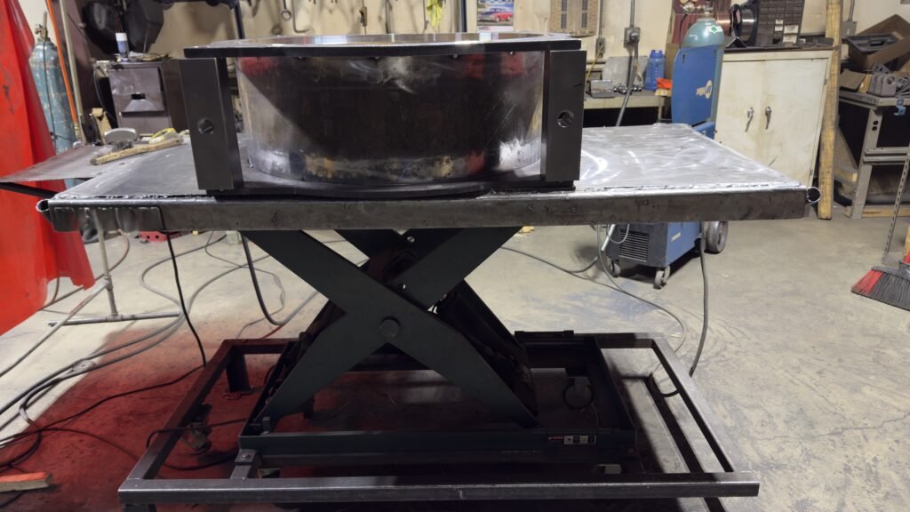 heavy steel welding table in fabrication shop with flat plate surface and welded frame base